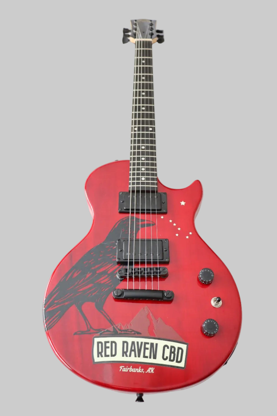 Red electric guitar with 'Red Raven CBD' branding on a white background